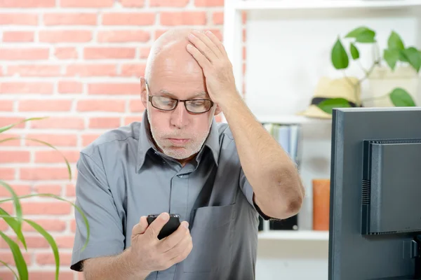 An anxious man looks at his smartphone — Stock Photo, Image