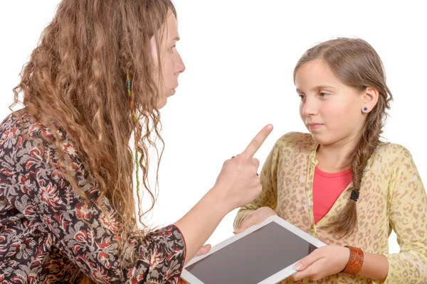 Enojada madre regañando a la hija porque ella paleando con una tableta digital — Foto de Stock