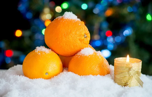 Drei Orangen im Schnee mit Weihnachtsdekor — Stockfoto