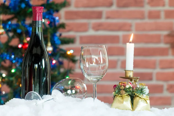 Una botella y dos copas de vino en la nieve frente a un Chris — Foto de Stock