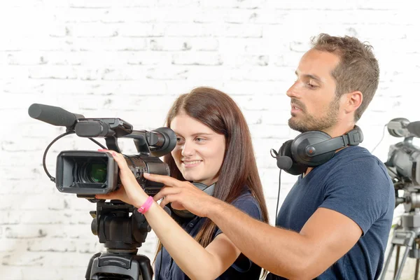 Молодой человек и женщина с профессиональной видеокамерой — стоковое фото