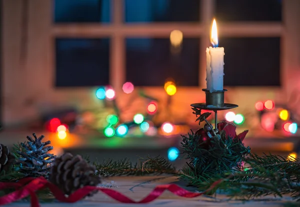 Svíčka s vánoční výzdobou, rozmazané světlé pozadí — Stock fotografie