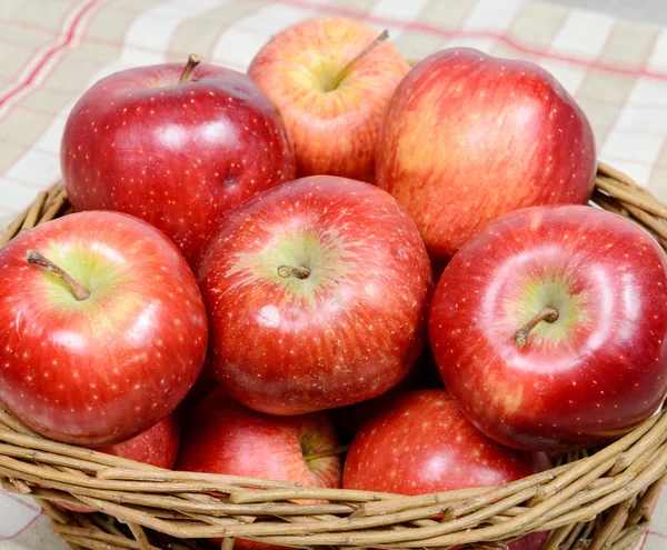 Červená jablka v proutěném košíku — Stock fotografie