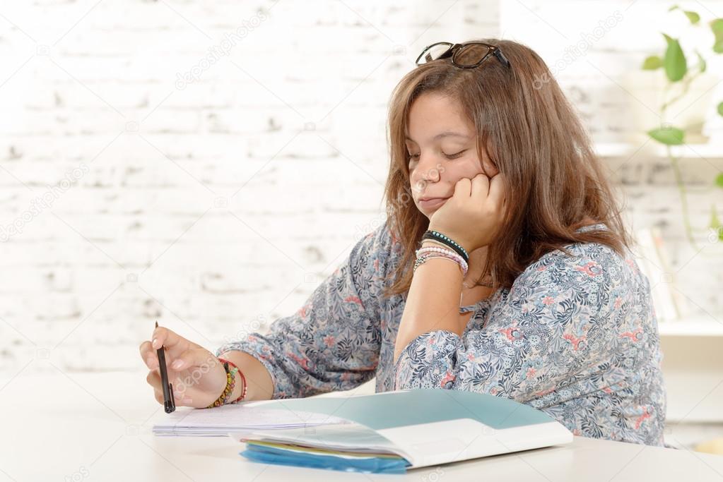  student girl, with eyeglasses, does homework