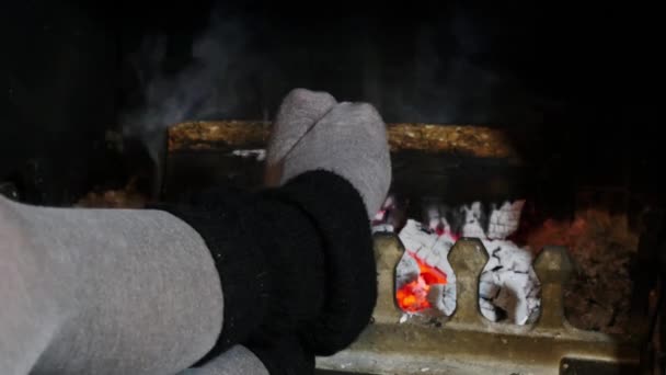 Kvinnan uppvärmningen hennes fötter vid brasan — Stockvideo
