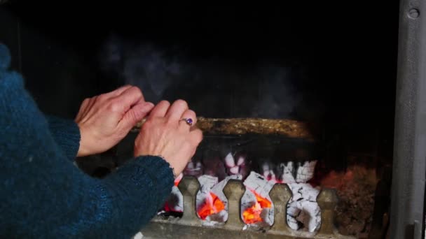 Mujer calentando sus manos junto a la chimenea — Vídeo de stock
