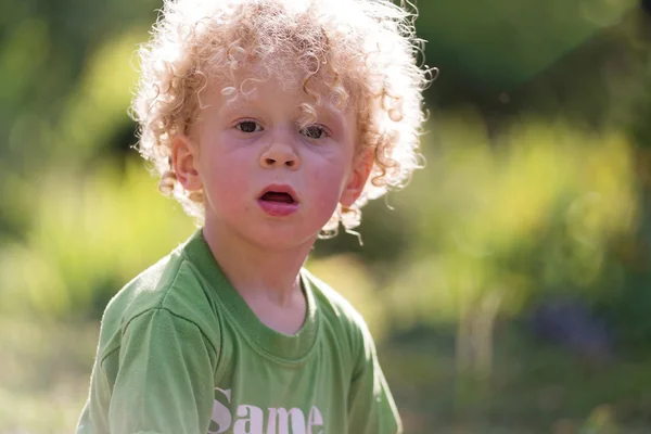 Portret van een kleine blonde krullend jongen, buiten — Stockfoto