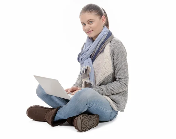 Mooi meisje zit met gekruiste benen met een laptop op knieën — Stockfoto
