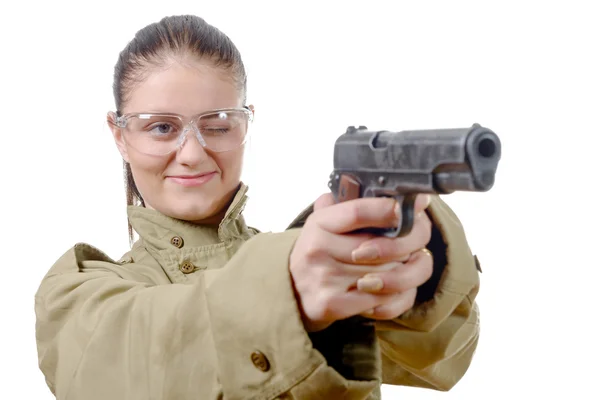 Jonge vrouw met beschermende bril houdt een pistool — Stockfoto