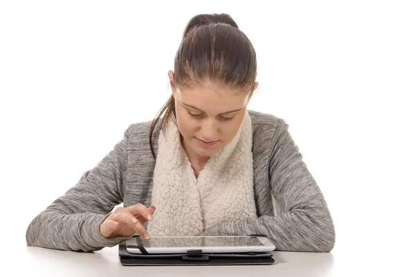 Schöne junge Frau schaut auf Tablet-Computer — Stockfoto