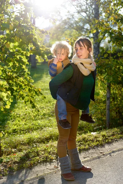 幸せな若い母親と彼女の息子の秋の公園で時間を過ごす — ストック写真