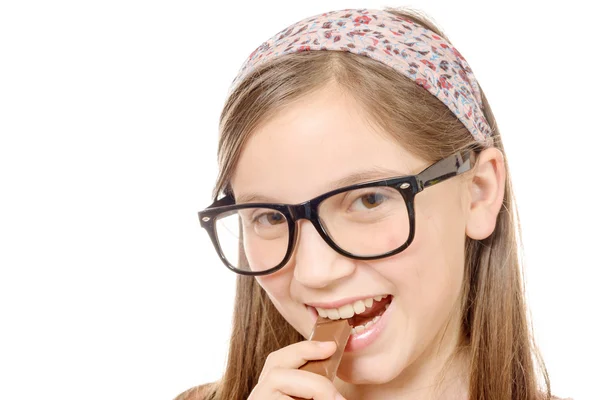 Retrato de una joven comiendo una barra de chocolate aislada en el blanco —  Fotos de Stock