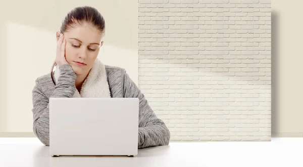 Mujer joven que trabaja con una computadora portátil blanca — Foto de Stock