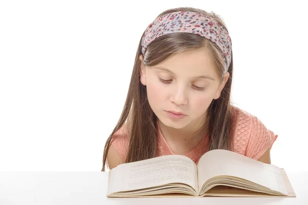 Kleine Schülerin lernt und liest Buch in der Schule — Stockfoto