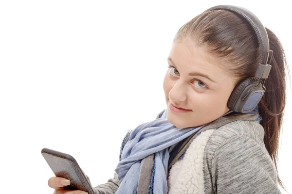 Jovem mulher ouvindo música com seu telefone celular e headph — Fotografia de Stock