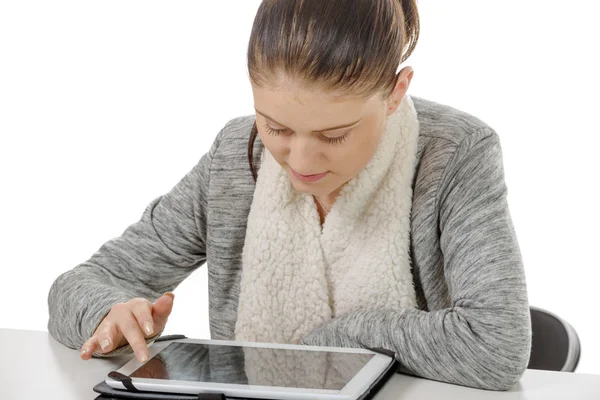 Schöne junge Frau schaut auf Tablet-Computer — Stockfoto