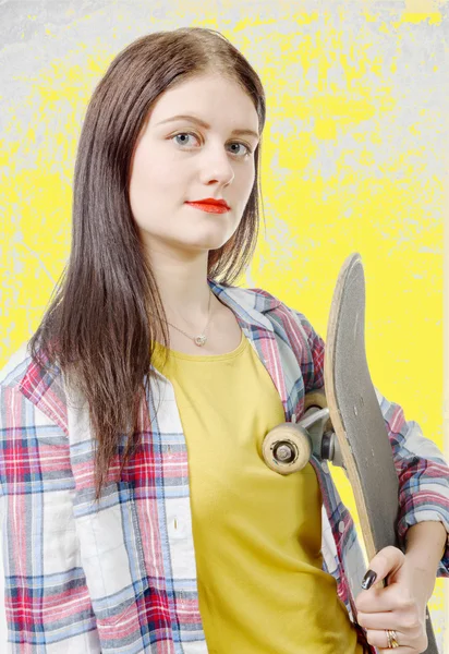 Portrét mladé bruslaře dívku drží skateboard — Stock fotografie