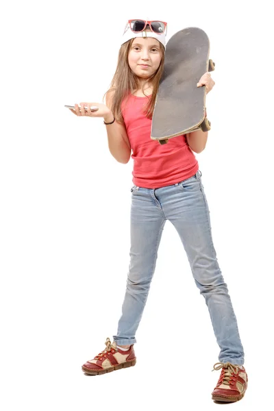 Hübsches kleines Mädchen mit Skateboard und Handy, auf weiß — Stockfoto