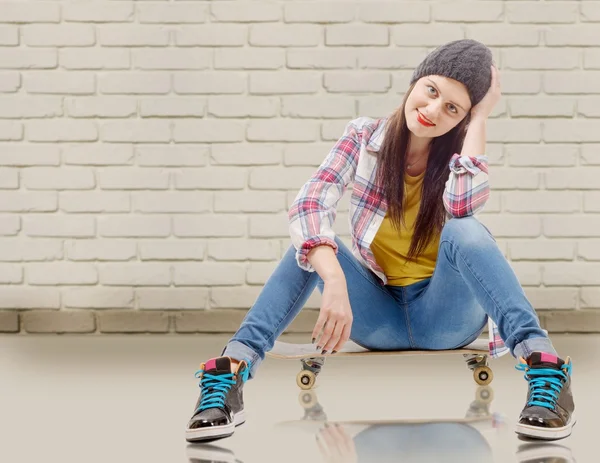 Vacker ung kvinna poserar med en skateboard, plats på skate — Stockfoto