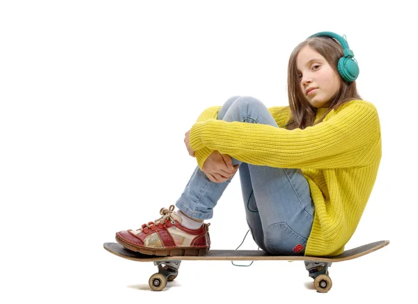 Симпатичная молодая девушка, позирующая со скейтбордом, сидящая на коньках, l — стоковое фото