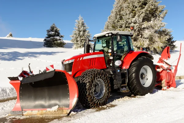 Grote rode trekker met sneeuw ploegen een winters — Stockfoto