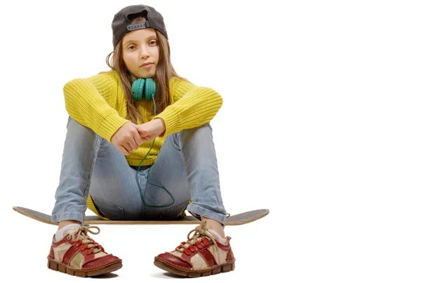 Jolie jeune fille posant avec un skateboard, assise sur le skate — Photo