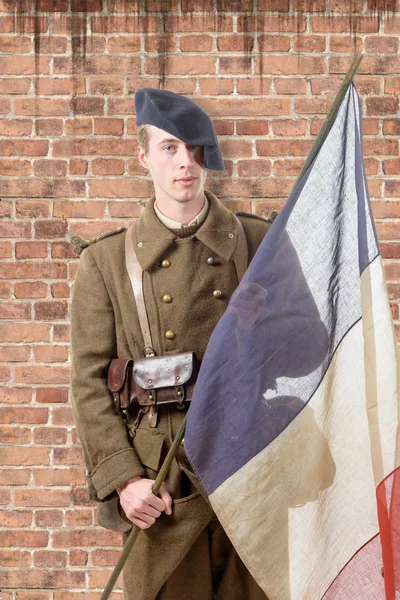 1940 soldado francês com uma bandeira, parede de tijolo vermelho na parte de trás — Fotografia de Stock