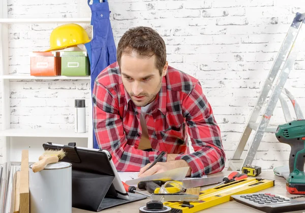 Atractivo joven usando la tableta para bricolaje — Foto de Stock