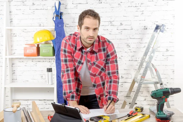 Joven trabajador sonriente en su taller — Foto de Stock