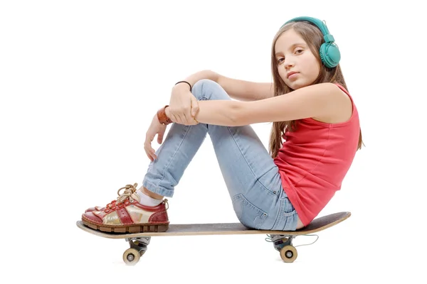 Jolie jeune fille posant avec un skateboard, assis sur le skate, li — Photo