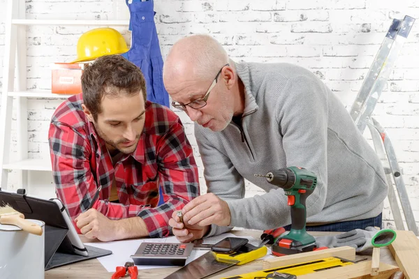 Dos técnicos examinando parte mecánica en el taller — Foto de Stock