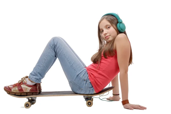 Jolie jeune fille posant avec un skateboard, assis sur le skate, o — Photo