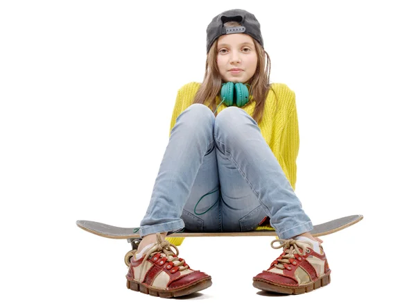 Ganska ung flicka poserar med en skateboard, sitter på skate, o — Stockfoto