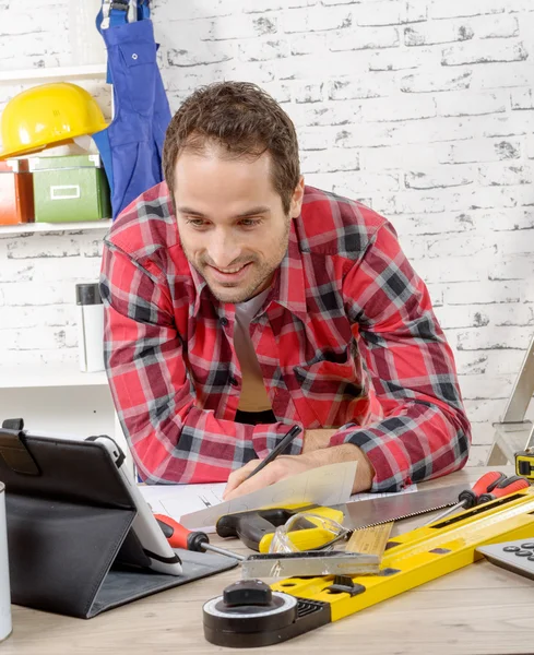 Jovem sorrindo usando o tablet para DIY — Fotografia de Stock