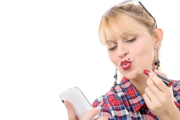 Schöne Mädchen setzt auf roten Lippenstift auf ihren Lippen, als er reflektiert — Stockfoto