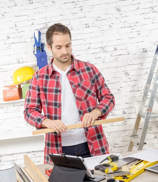 Junger Arbeiter mit einem Holzbrett — Stockfoto