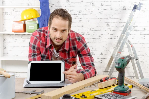 Smiling young carpenter showing thescreen on digital tablet — Stock Photo, Image