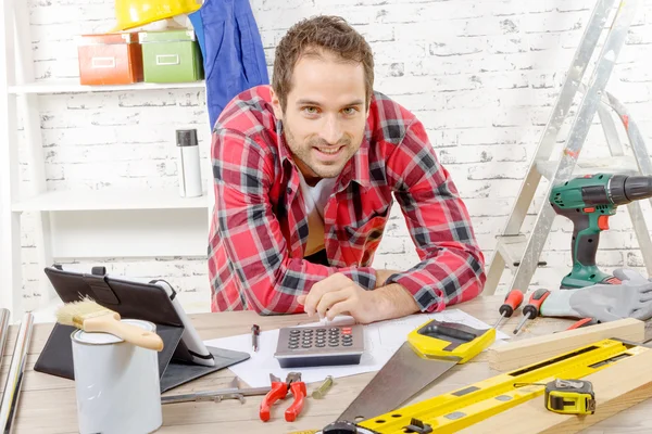 Lachende jonge timmerman in zijn atelier — Stockfoto