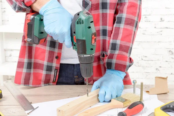 Carpenter drilling hole in plank, in his workshop — Stock Photo, Image