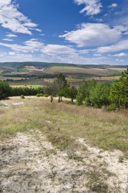 Güneşli mavi gökyüzü, çayır ve Katselovo köyü yakınlarında bir tepe