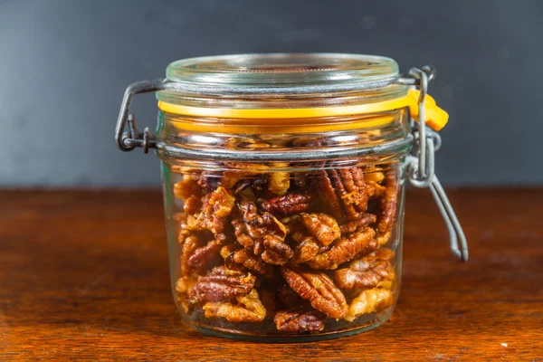 Jar with mixed garlic and rosemary roasted nuts. — Stock Photo, Image