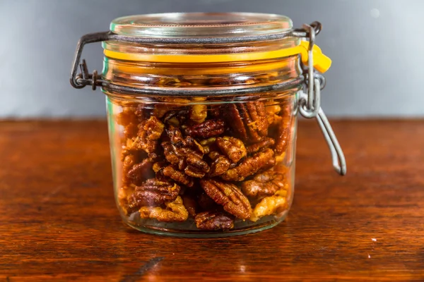 Jar with mixed garlic and rosemary roasted nuts. — Stock Photo, Image