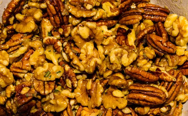 Mix nuts covered in butter garlic and rosemary mixture before ro — Stock Photo, Image
