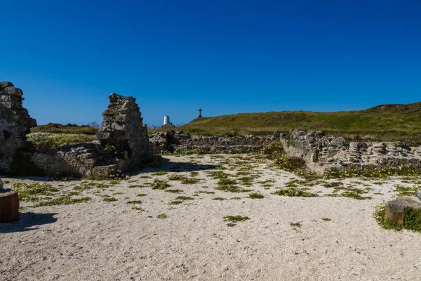 Ruine der llanddwyn-Kapelle, Anglesey, Kreuz und Leuchtturm in dist — Stockfoto