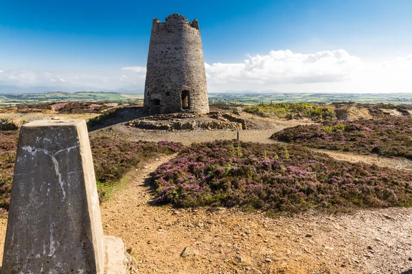 Punto de trigonometría con molino de viento abandonado, Montaña Parys . — Foto de Stock