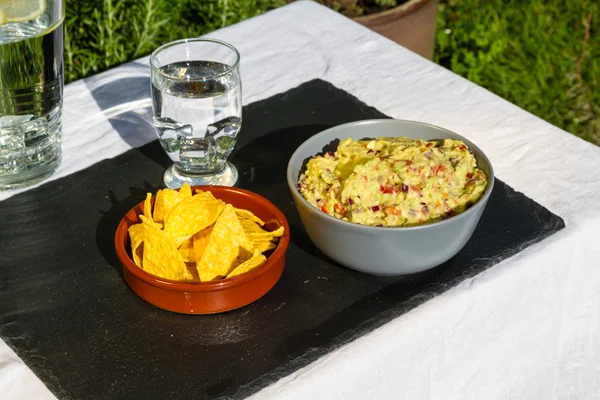 Guacamole in Schüssel mit Tortilla-Chips und Eiswasser. im Freien o — Stockfoto