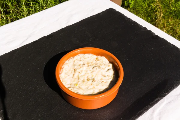 Auberginen-Dip in Keramikschale im Freien auf Schiefermatte. — Stockfoto