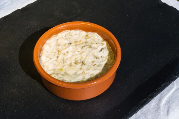 Auberginen-Dip in Keramikschale im Freien auf Schiefermatte. — Stockfoto