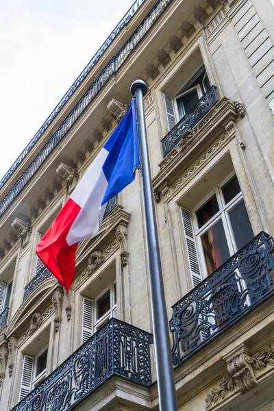 Franse vlag tegen straat gebouwen — Stockfoto