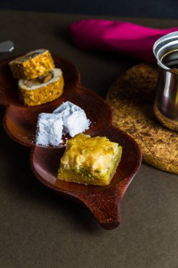 Türk Lokumu ve Baclava, fincanlı, çay tabağı ve su bardağıyla birlikte Türk kahvesi ile servis edilir. Düşük ışıklandırma, portre.